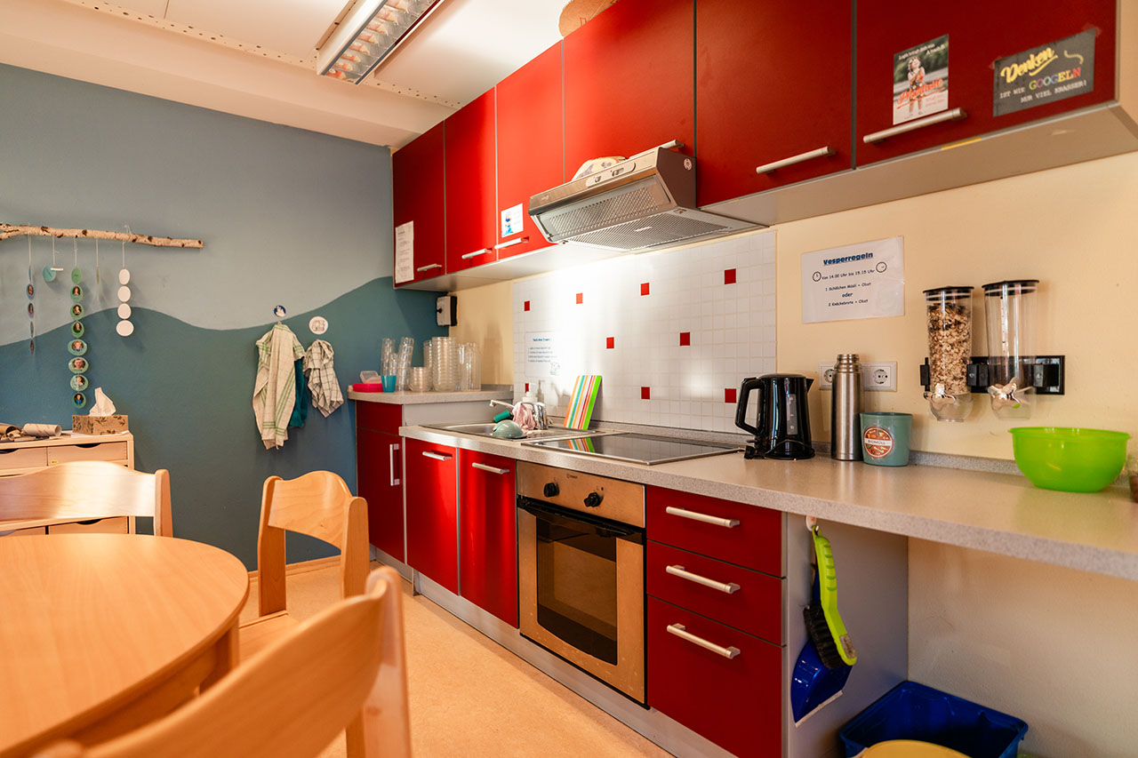 ein Kita-Raum mit einer roten Küche
