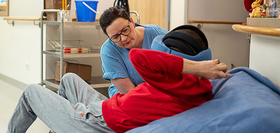 Eine Pflegerin auf Station 5 der Fachklinik für Neurologie im Epilepsiezentrum Kleinwachau in Radeberg bei Dresden hilft einem Epilepsie-Patienten beim Aufstehen.