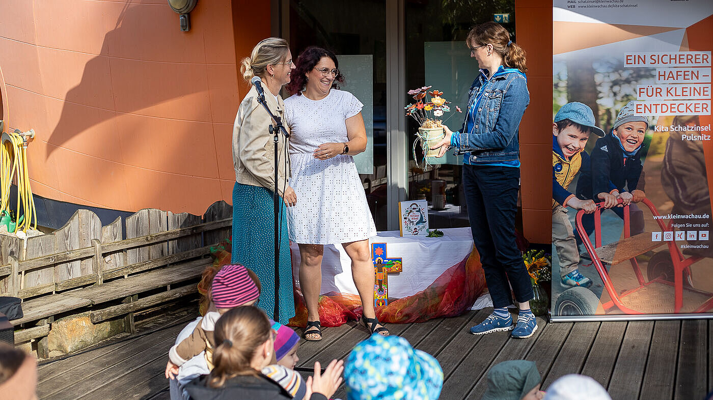 Sandra Stöhr, Geschäftsführerin des Epilepsiezentrums Kleinwachau, Mirjam Queisser, Bereichsleiterin Bildung Epilepsiezentrums Kleinwachau, gratulieren Vivien Richter, Leiterin des Evangelischen Kinderhauses Schatzinsel in Pulsnitz, zum 20jähigen Bestehen der Einrichtung.