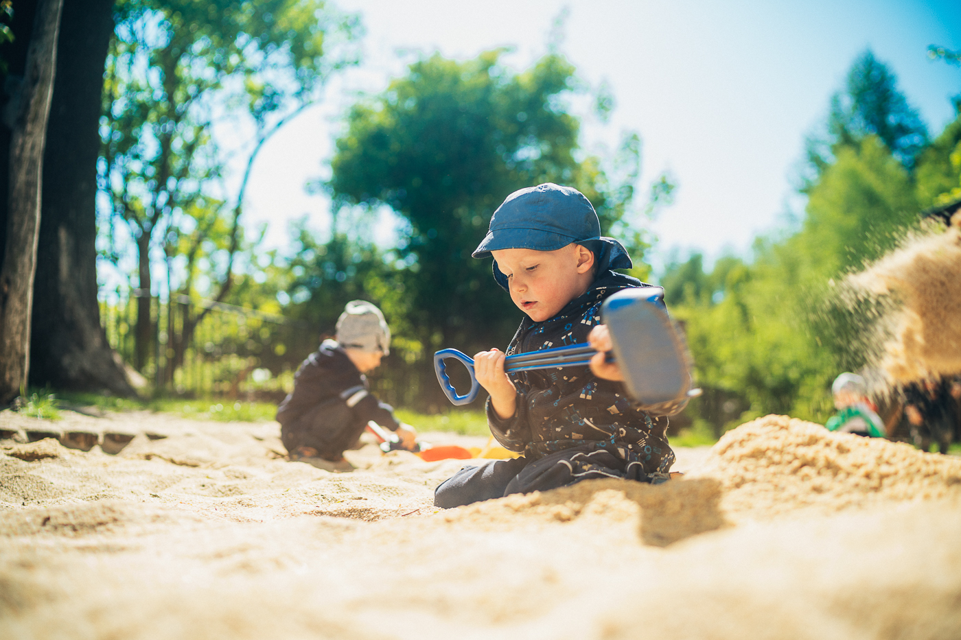 Drei kleine Kinder spielen im Sandkasten in den Außenanlagen der Kita Schatzinsel in Pulsnitz in Sachsen. Die Kita Schatzinsel gehört zum Epilepsiezentrum Kleinwachau in Radeberg.