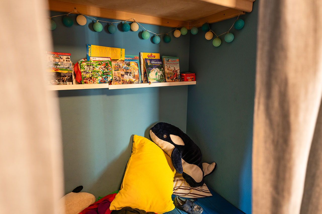 ein Rückzugsort hinter einem Vorhang mit Büchern und einem Kuschel-Delphin